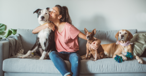Happy healthy dogs and owner sitting together, celebrating National Pet Day.